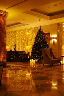 a christmas tree in the middle of a hotel lobby by Dmitry Spravko courtesy of Unsplash.