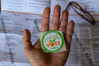 person holding green and white round plastic container by Mick Haupt courtesy of Unsplash.